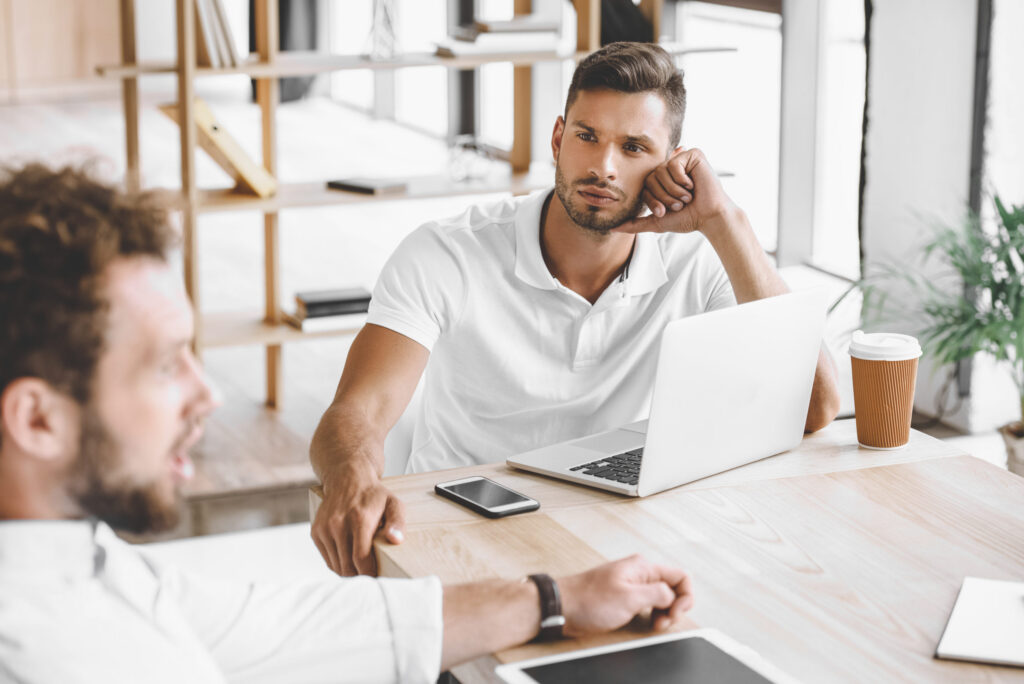 Two colleagues discussing work at a laptop