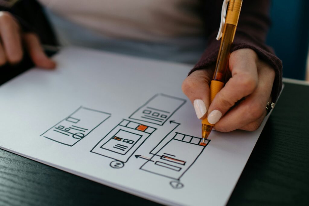 Hand sketching a website wireframe on paper