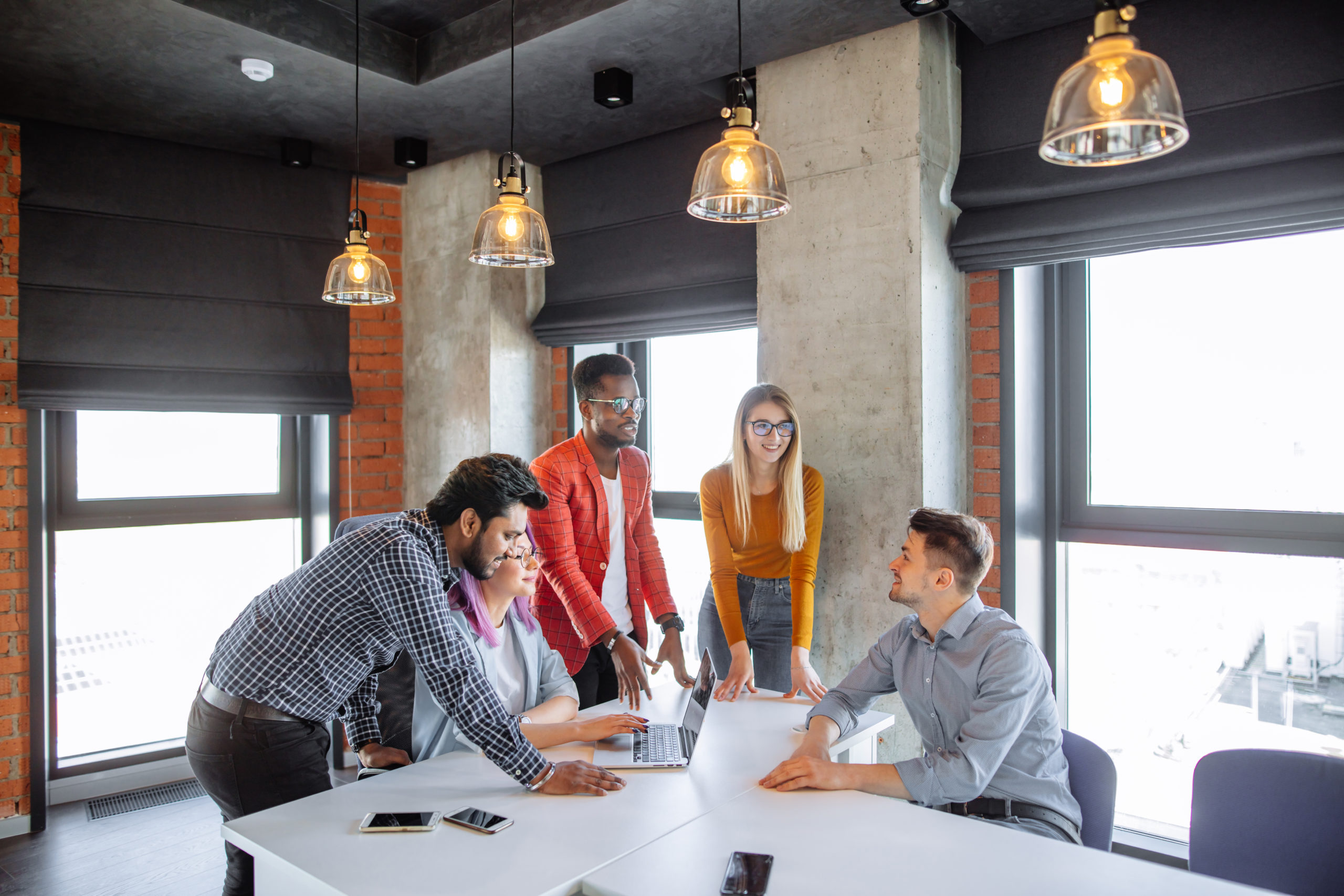 Team meeting in a modern office with industrial-style lighting